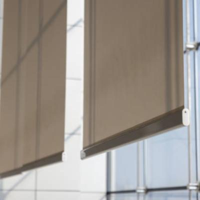 white curtain or white blinds Roller sun protection in office near large windows.